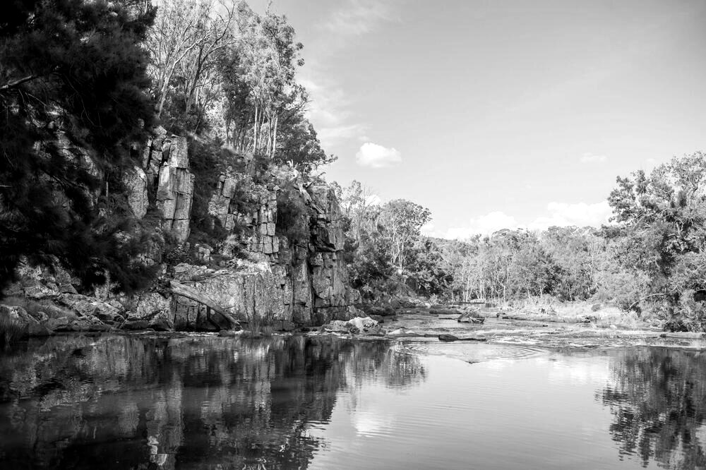 The river gorge at Ben's Falls Retreat, calm water beneath sandstone cliffs
